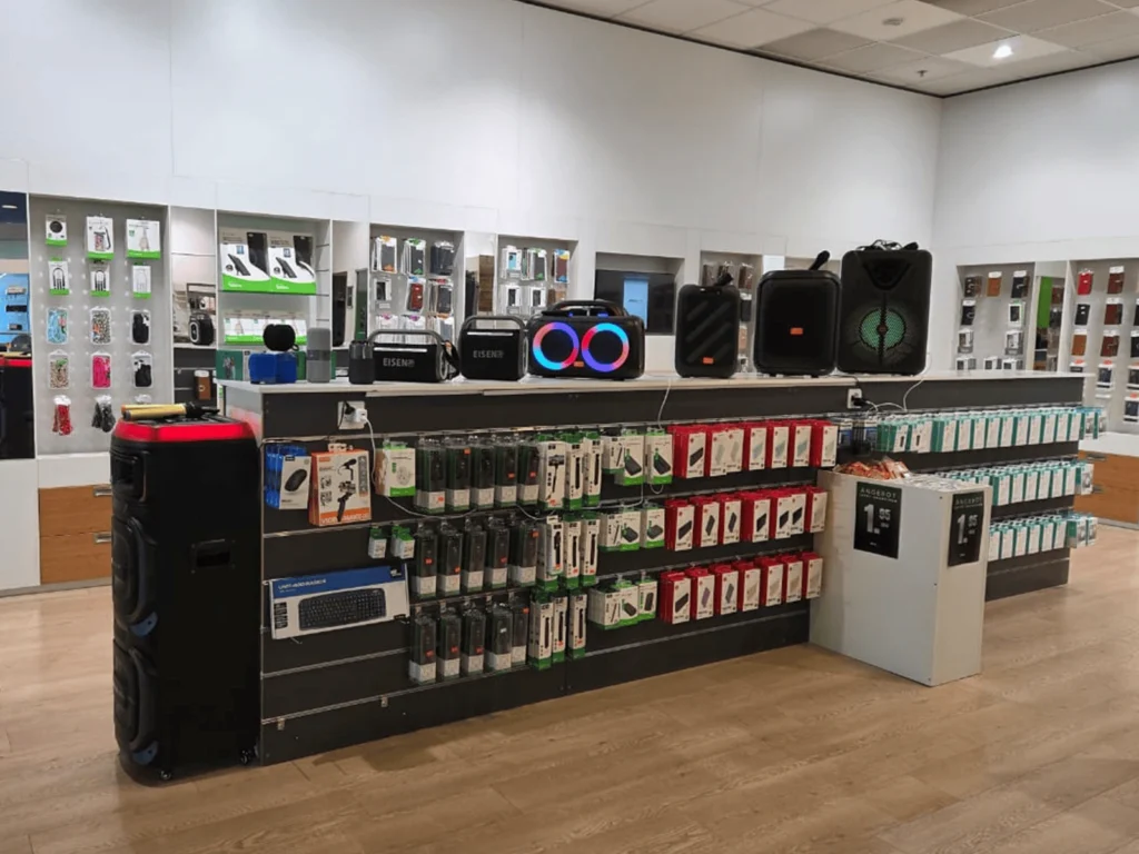 Eine beleuchtete Glasschautheke im phonezone Geschäft St. Gallen, in der verschiedene gebrauchte und neue Smartphones sowie Tablets verkaufsbereit ausgestellt sind.